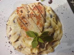 Tortellini pasta stuffed with cheese served with mushroom sauce and parmesan 